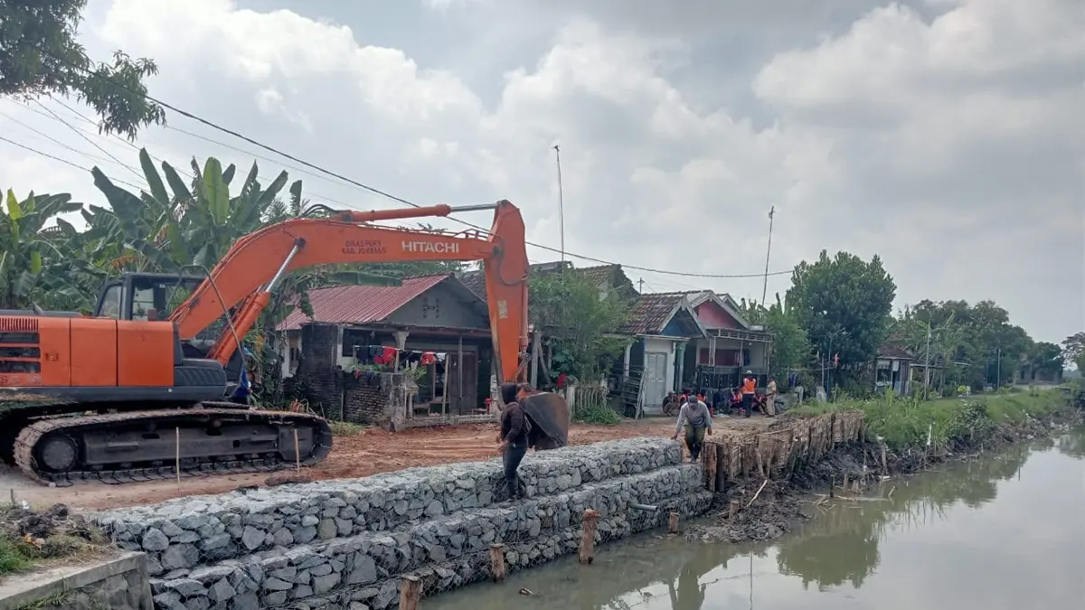 DITANGANI: Tanggul saluran buang Ndero di Dusun Kedungmacan, Desa Kedungbetik, Kecamatan Kesamben, Jombang yang longsor dipasang bronjong, (18/5). (Ainul Hafidz/Radar Jombang)