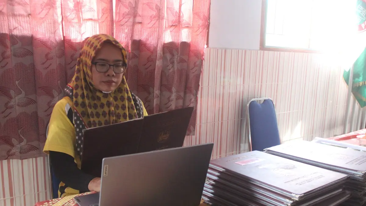 PENDAMPINGAN: guru SDN Mojongapit 3 Jombang membantu siswa unggah data ke sistem SPMB. (Wenny Rosalina/Radar Jombang)