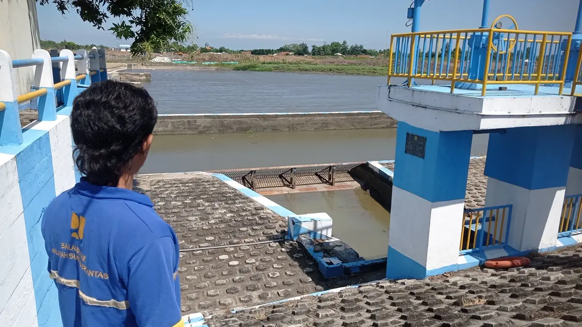 MACET: Operator Dam Karet Jatimlerek menunjukkan intake (bangunan bagi sadap) DI (Daerah Irigasi) Jatimlerek, Jombang yang tak lagi teraliri air Sungai Brantas. (Ainul Hafidz/Radar Jombang)