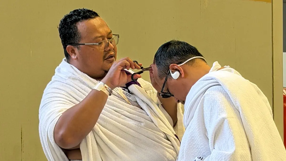TAHALUL: Ketua Rombongan 1 SUB Kloter 61 sekaligus Pembimbing Ibadah Haji (PIH) KBIHU Thoriqul Jannah, Jombang, Zulfikar Damam Ikhwanto Adhim, mencukur rambut jemaah. 