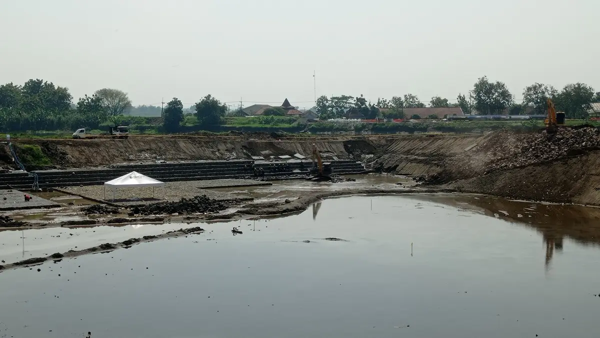 UNTUK SEMENTARA: Tanggul Sungai Brantas di sisi Desa Sudimoro, Kecamatan Megaluh, Jombang dikeruk untuk pembuatan saluran pengelak keperluan proyek rehab Bendung Jatimlerek. (Ainul Hafidz/Radar Jombang)