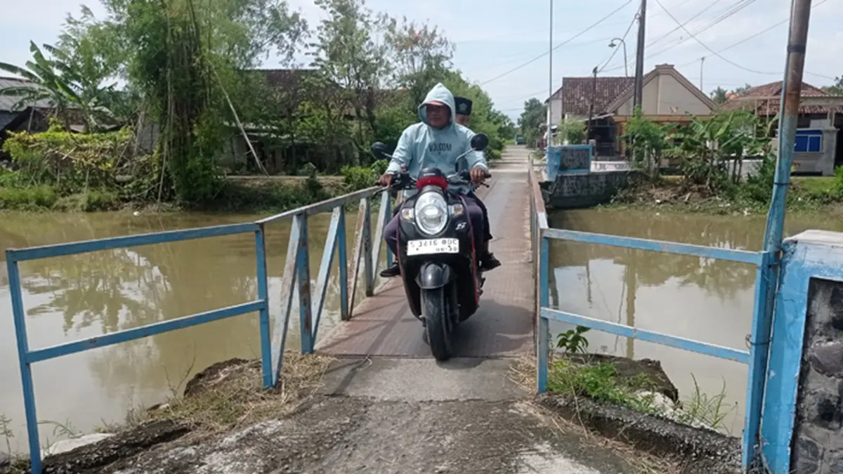 Warga melintas di jembatan sementara Desa Kudubanjar, Kecamatan Kudu, Jombang. (Ainul Hafidz/Radar Jombang)