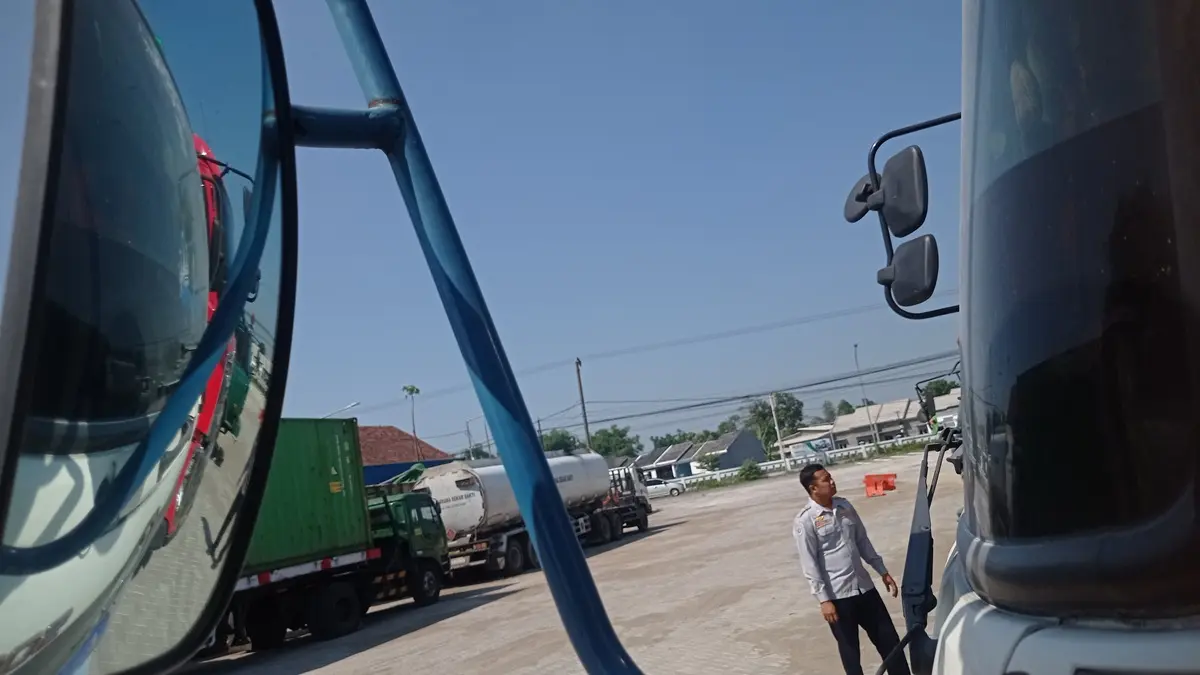 DIPARKIR: Petugas mengecek kendaraan barang yang parkir di Terminal Barang Desa Glagahan, Kecamatan Perak, Jombang. (Ainul Hafidz/Radar Jombang)