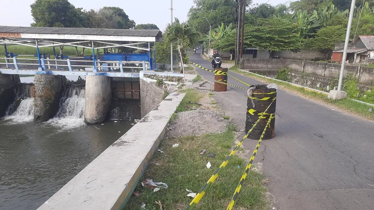 DITANDAI DRUM: Kondisi jalan di Desa Candimulyo ambles di sisi jalan tepat di samping Dam Pancasila, Senin (15/6). (Anggi Fridianto/Radar Jombang)