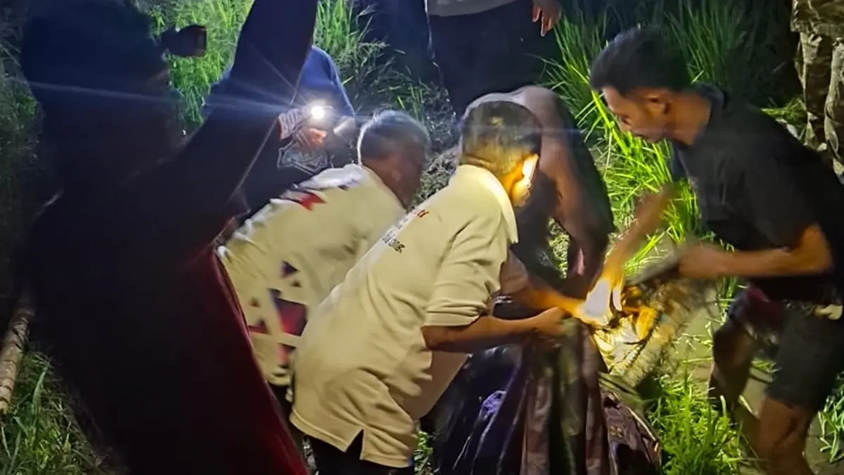 EVAKUASI: Warga mengevakuasi jasad Muhadi, 56, yang meninggal di area persawahan Dusun Semanding, Desa Kalangsemanding, Kecamatan Perak, Jombang, Jumat (19/6) malam. (Achmad RW/Radar Jombang)