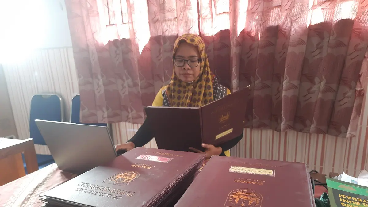 DIPROSES: Guru SDN Mojongapit 3, Jombang mengunggah nilai rapor siswa untuk keperluan SPMB SMP. (Wenny Rosalina/Radar Jombang)