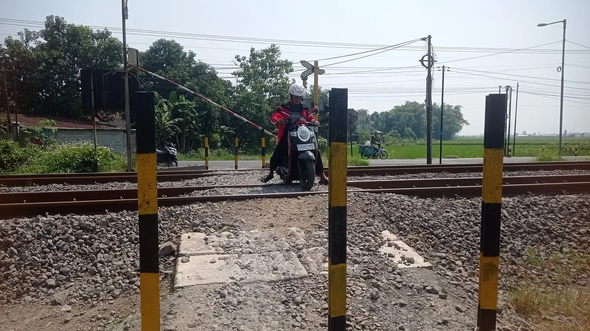 Warga melintas di perlintasan KA Desa Nglele, Kecamatan Sumobito yang diusulkan dibangun palang pintu.