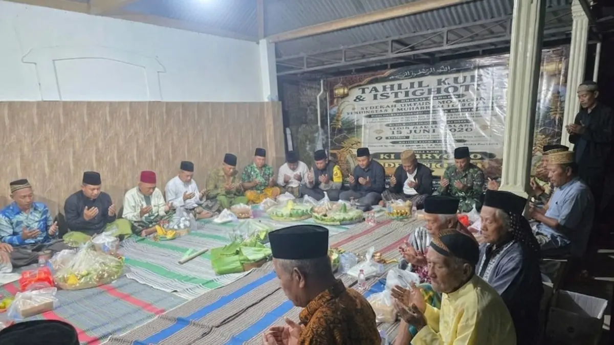 LESTARI: Kepala Desa Balongbesuk M. Saifur membaur bersama warga dan tamu undangan saat berdoa di punden leluhur area makam umum Dusun Mojosongo, Desa Balongbesuk, Diwek, Jombang, Senin (15/6) malam. (Dwi Aris/Radar Jombang)