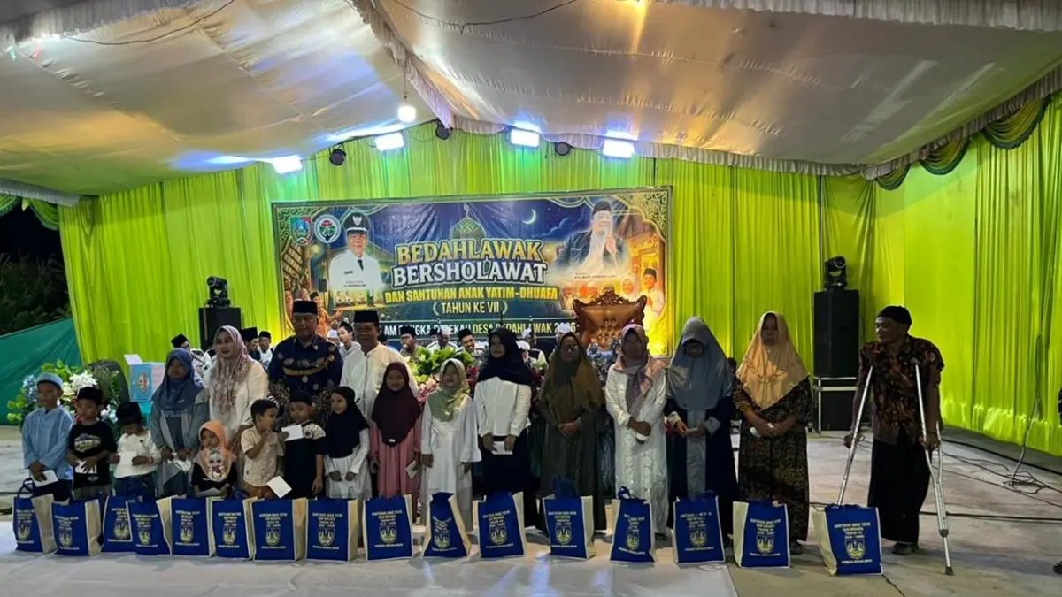 BENTUK KEPEDULIAN: Kepala Desa Bedahlawak Masrum (tengah berbaju putih) memberikan santunan kepada anak yatim dan warga duafa dalam acara sedekah Desa Bedahlawak, Tembelang, Jombang di Masjid Nurul Iman, Kamis (25/6) malam. (Dwi Aris/Radar Jombang)