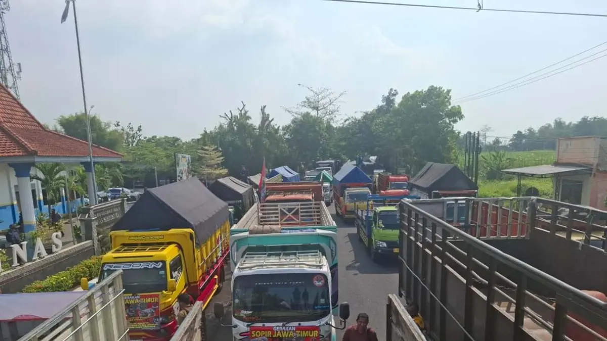 Sopir truk yang tergabung dalam Gerakan Sopir Truk Jawa Timur (GSJT) memblokade jalan nasional di depan Kantor Dinas Perhubungan (Dishub) Jombang, Kamis (25/6). (Achmad RW/Radar Jombang)