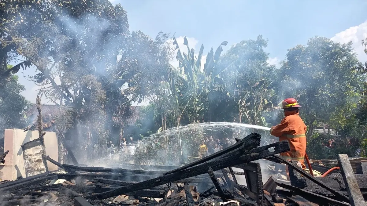 EVAKUASI: Petugas BPBD Jombang melakukan evakuasi kebakaran rumah Mariyam, 75, warga Dusun Tondowesi, Desa Klitih, Kecamatan Plandaan, Jumat (26/6). (Achmad RW/Radar Jombang)