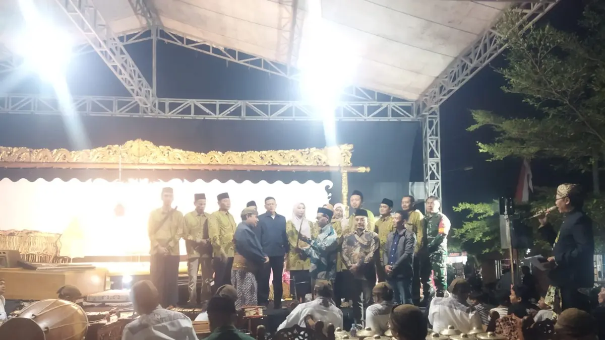 SIMBOLIS: Kepala Desa Karangwinongan Iknan menyerahkan wayang secara simbolis kepada Ki Dalang Tatut Sutanto saat acara sedekah desa, Selasa (16/6) malam. (Dwi Aris/Radar Jombang)