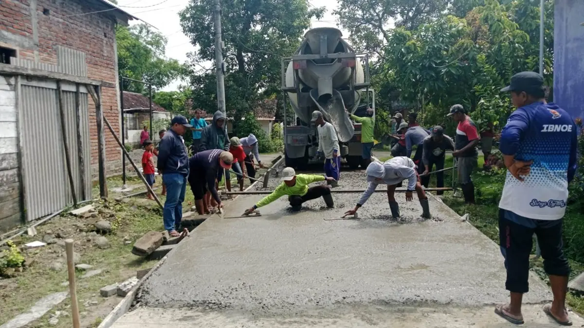 BANGUN INFRASTRUKTUR DESA: Pj Kepala Desa Kampungbaru Daniel Danang Darmawan didampingi jajaran perangkat desa saat meninjau pelaksanaan pembangunan jalan rabat beton di Dusun Kepuh, Desa Kampungbaru, Plandaan, Jombang, Sabtu (30/5). (Dwi Aris/Radar Jombang)
