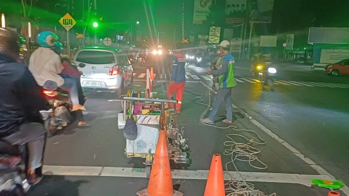 MULAI DIGARAP: Proyek marka jalan di Jl KH Wahid Hasyim, Jombang, Minggu (28/6) malam. (Ainul Hafidz/Radar Jombang)
