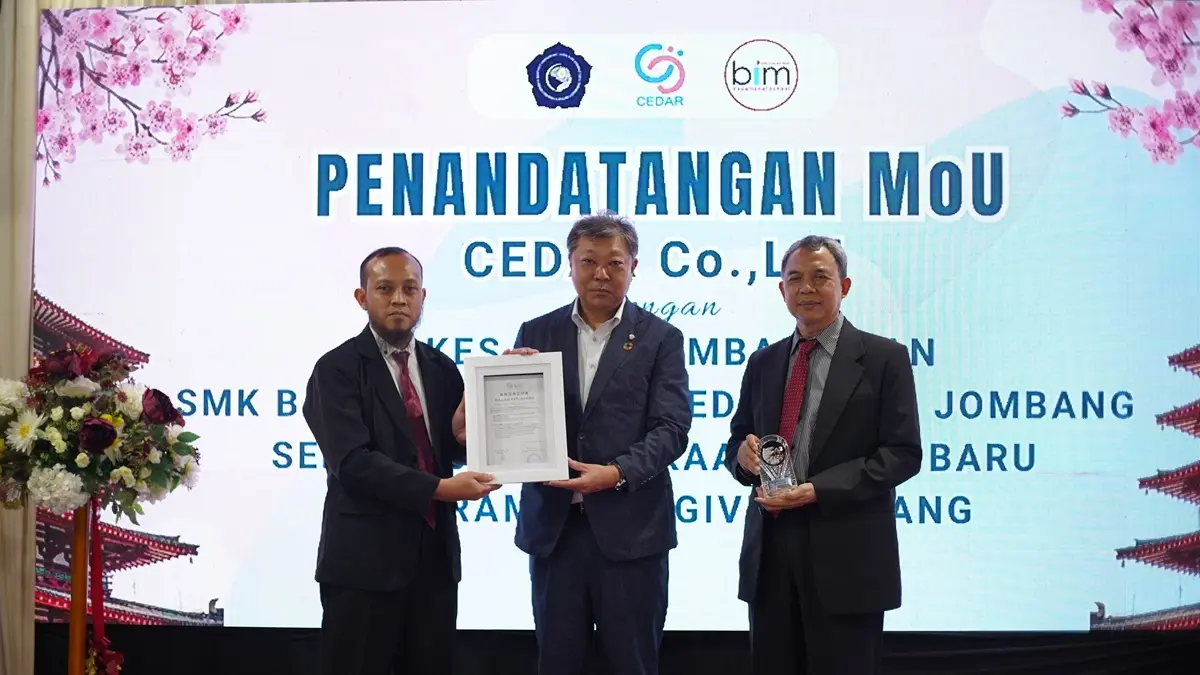 RESMI: Direktur Utama Cedar Co Ltd Jepang Takayazu Zakoda (tengah) menyerahkan piagam kerja sama kepada Waka Humas SMK BIM Jombang Ardi Subagiyo MPd (kiri). (Dwi Aris/Radar Jombang)