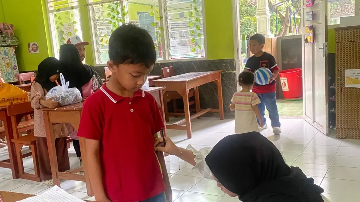 TEPAT DAN AKURAT: Penjahit melakukan pengukuran seragam di SDN Jombatan 3 Kecamatan Jombang 2025. (Wenny Rosalina/Radar Jombang)