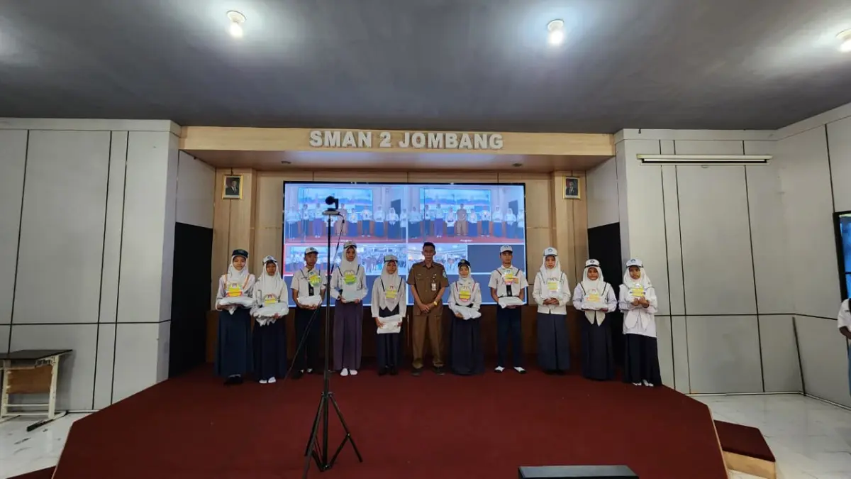 Kepala SMAN 2 Jombang, Budiono MMPd memberikan seragam kepada siswa kurang mampu, Senin (13/7).