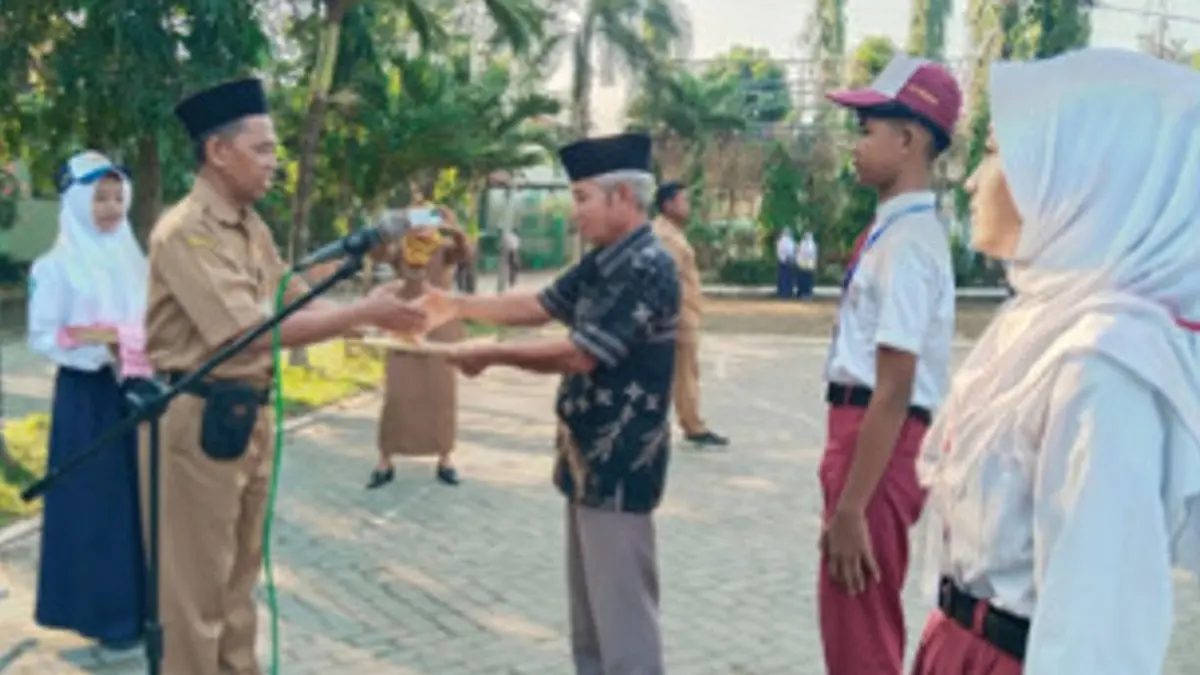 KREATIF: Kepala SMPN 1 Megaluh, Jombang, Drs Ahmad Su’ud, menyambut perwakilan orang tua dan murid baru saat pembukaan MPLS, Senin (13/7) pagi. (Dwi Aris/Radar Jombang)