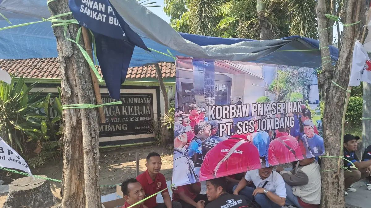 Puluhan buruh PT Sumber Graha Sejahtera (SGS) Jombang yang terdampak pemutusan hubungan kerja (PHK) massal mendirikan tenda keprihatinan di depan Kantor Dinas Tenaga Kerja (Disnaker) Kabupaten Jombang di Jalan KH Wahid Hasyim, Jumat (17/7). (Achmad RW/Radar Jombang)