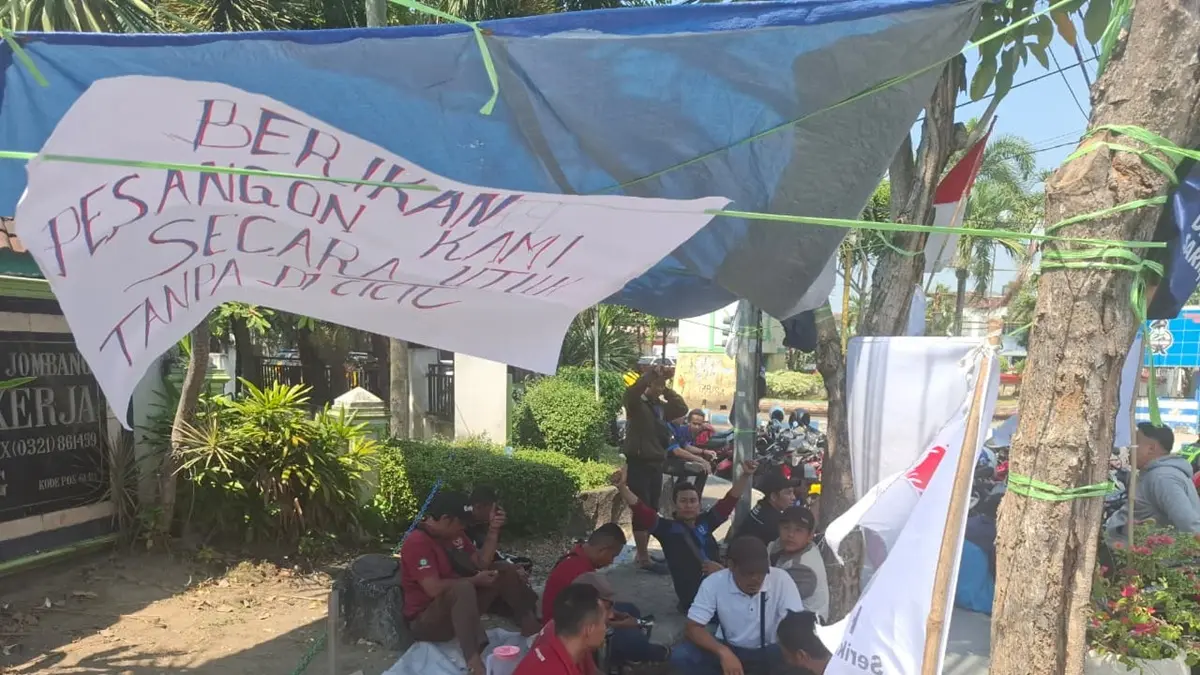 Puluhan buruh PT Sumber Graha Sejahtera (SGS) Jombang yang menjadi korban PHK massal mendirikan tenda keprihatinan di depan Kantor Dinas Tenaga Kerja (Disnaker) Kabupaten Jombang, Jumat (17/7). (Achmad RW/Radar Jombang)