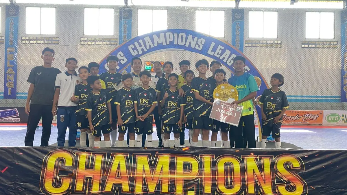 JUARA: Official dan pemain SDN Gadingmangu 2 Perak, Jombang menerima trofi juara turnamen Grassroots OFS League 2026, Minggu (5/7) siang. (Dwi Aris/Radar Jombang)
