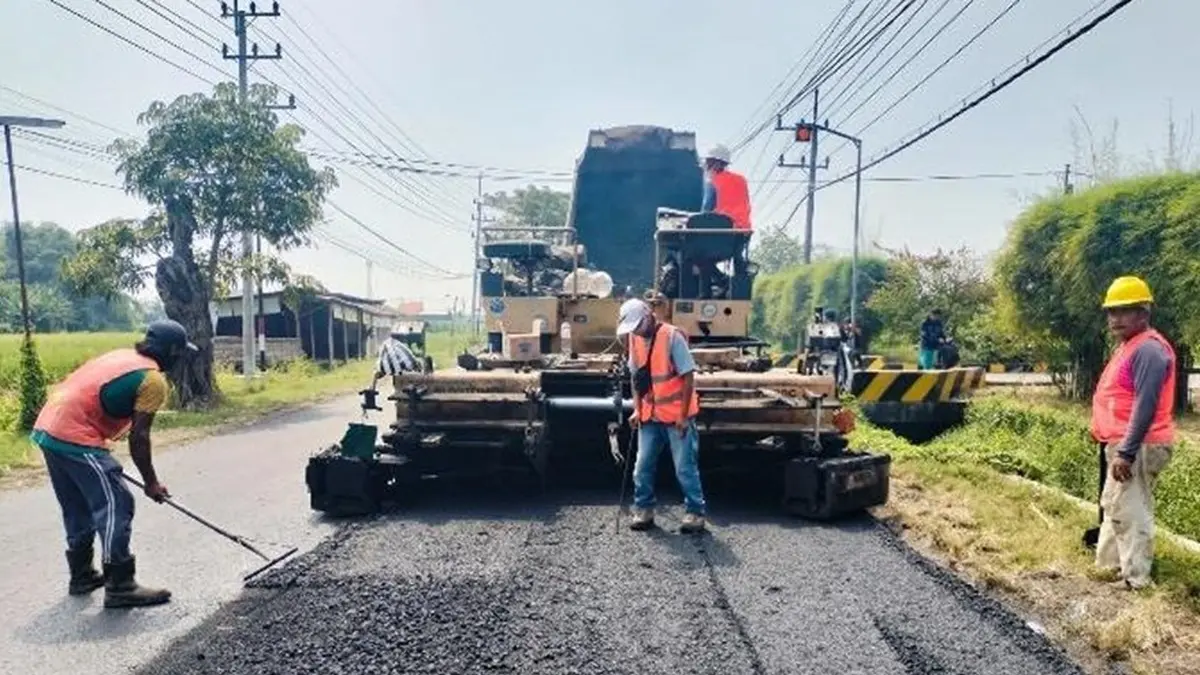 LEBIH LEBAR: Pekerja menyelesaikan pekerjaan proyek jalan Mojoagung-Mojoduwur, Jombang. (Ainul Hafidz/Radar Jombang)