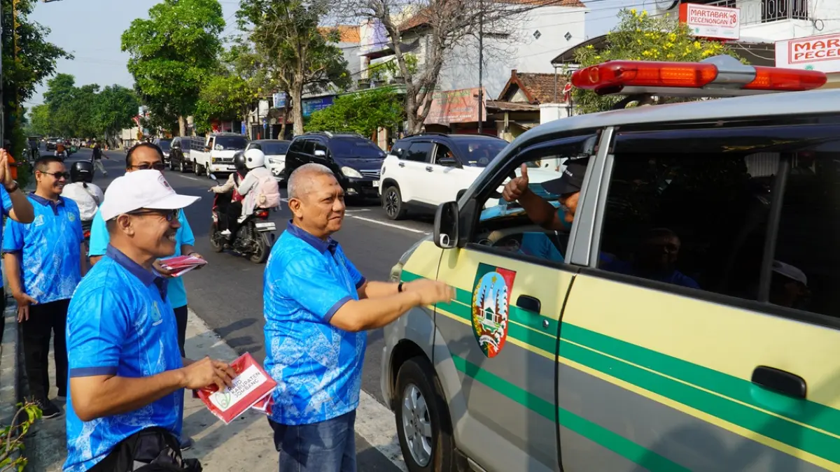 PEDULI: Direktur RSUD Kabupaten Jombang, dr Pudji Umbaran MKP, saat membagikan bendera merah putih di sekitar RSUD Jombang, kemarin (31/7). (Anggi Fridianto/Radar Jombang)