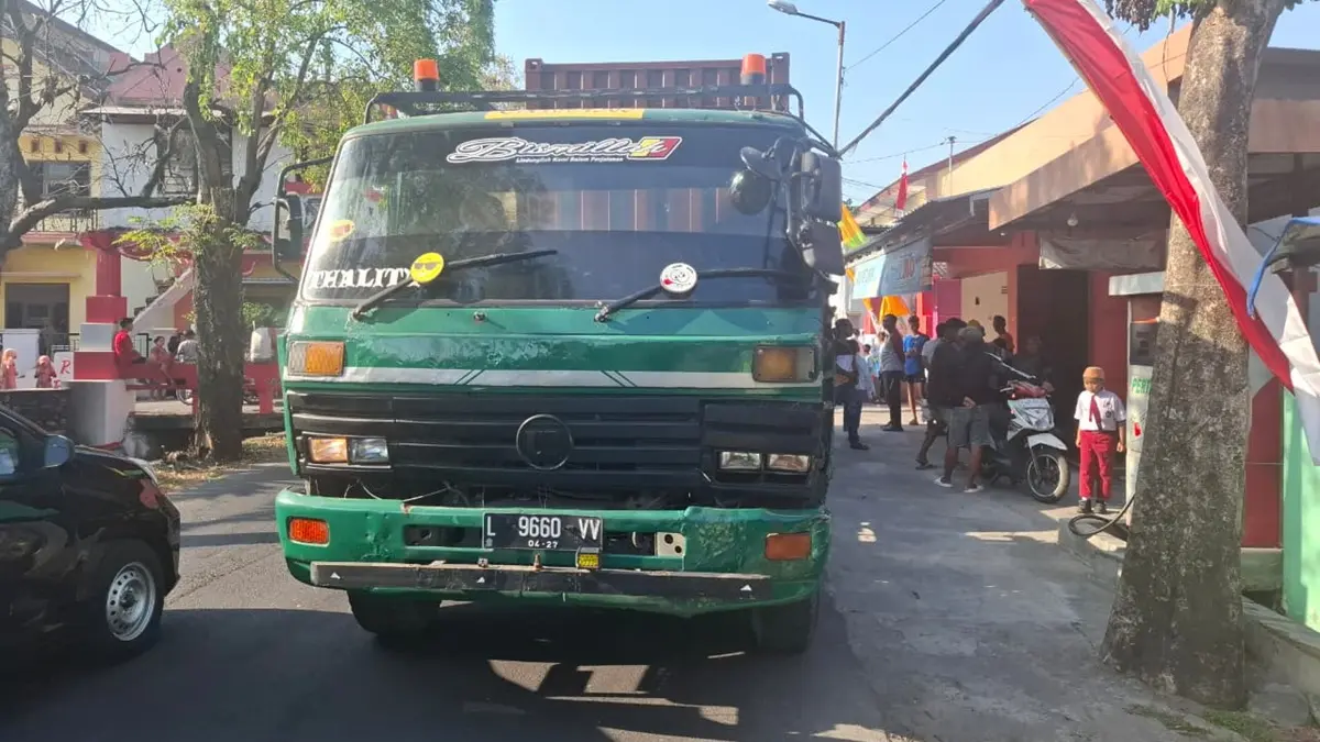 Sebuah truk kontainer menyeruduk dua rombong es teh dan satu sepeda motor di Jalan Kapten Pierre Tendean, Desa Sengon, Kecamatan Jombang, Senin (3/8) sore. (Achmad RW/Radar Jombang)