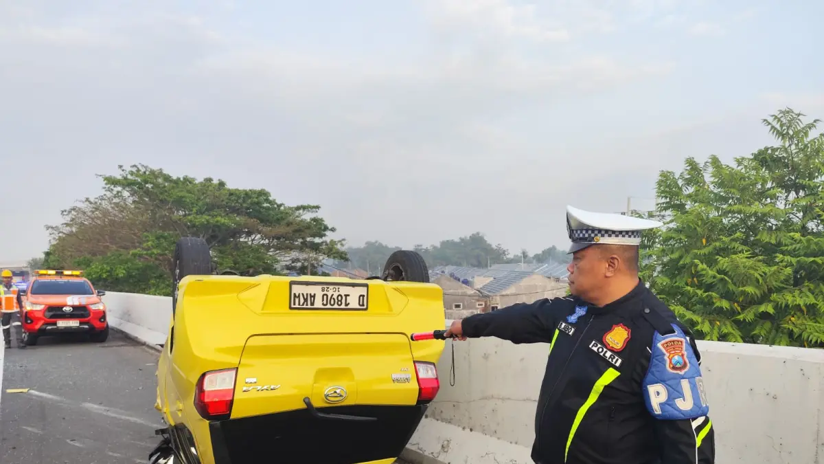 Polisi melakukan olah kejadian perkara kecelakaan ayla terbalik di Tol Jombang Mojokerto