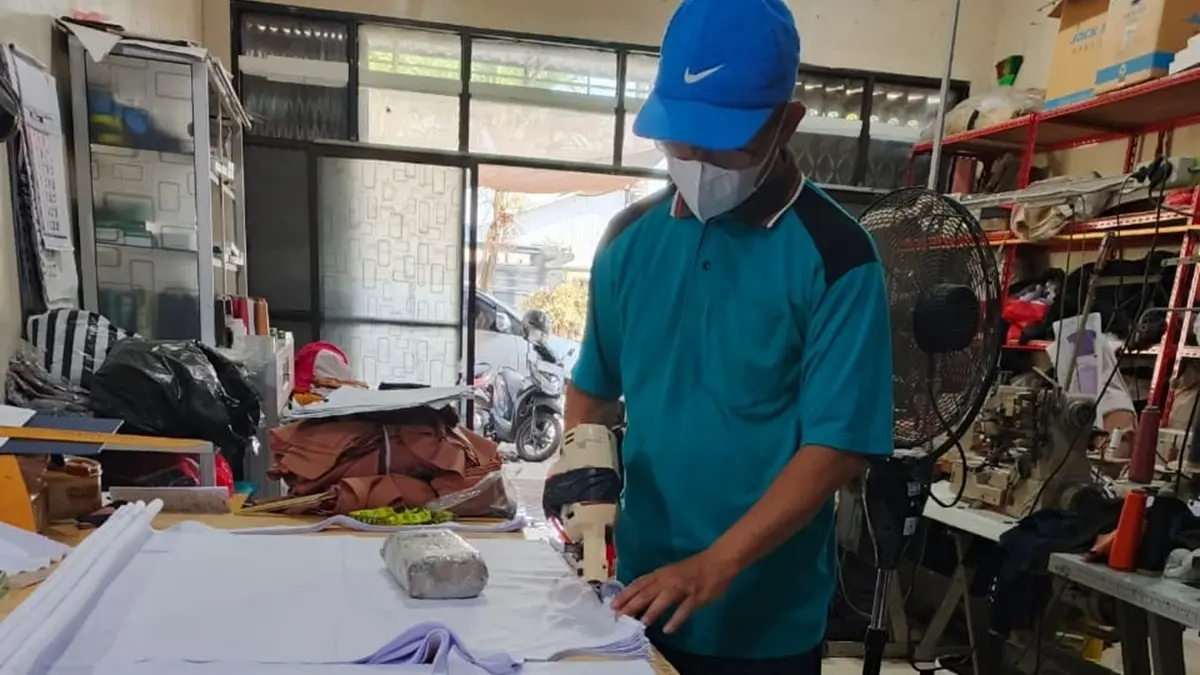 MULAI DIKERJAKAN: Salah satu penjahit di Desa Plosogeneng, Kecamatan Jombang mulai mengerjakan seragam gratis. (Wenny Rosalina/Radar Jombang)