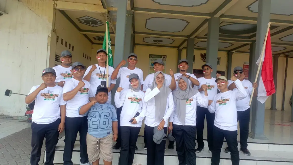 KOMPAK: Sekretaris Desa se-Kecamatan Peterongan memeriahkan gerak jalan se-Kecamatan Peterongan, Jombang dengan mengenakan kaos bertema Muktamar ke-35 NU, Rabu (12/8) siang. (Dwi Aris/Radar Jombang)