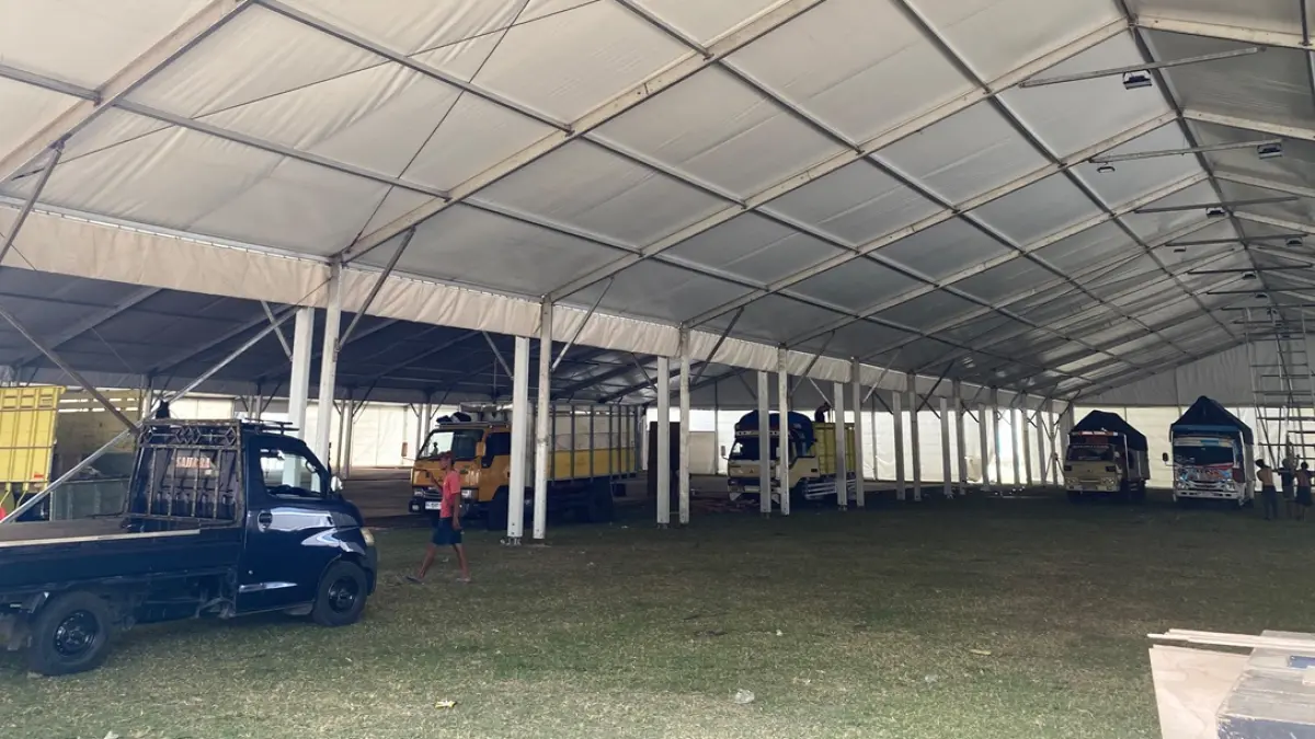 DIKEBUT: Pekerja mengebut pemasangan tenda roder di Lapangan Untung Suropati Tambakberas, Jombang, Senin (17/8). (Anggi Fridianto/Radar Jombang)