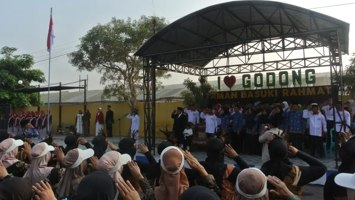 KHIDMAT: Kepala Desa Godong Dwi Marwati bertindak selaku inspektur upacara saat peringatan HUT ke-81 Kemerdekaan RI bersama warga di Taman Basra Desa Godong, Gudo, Jombang, Senin (17/8) pagi. (Dwi Aris/Radar Jombang)