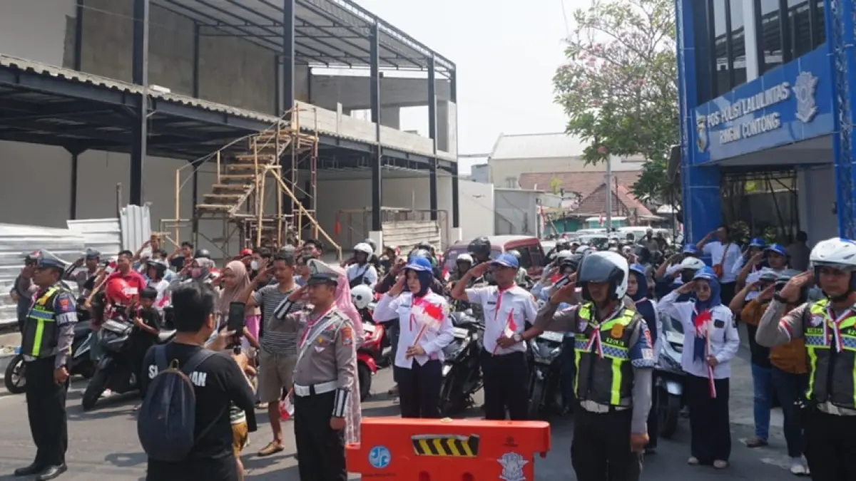 KHIDMAT: Pengguna jalan turut memberikan penghormatan peringatan Detik-Detik Proklamasi Kemerdekaan RI di simpang Ringin Contong, Jombang, Senin (17/8). (Achmad RW/Radar Jombang)