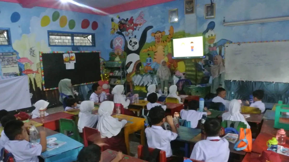 CANGGIH: Kepala SDIT Al Ummah Jombang, Setyowati Puji Rahayu mendampingi proses pembelajaran dengan menggunakan fasilitas smart tv di ruang kelas. (Dwi Aris/Radar Jombang)