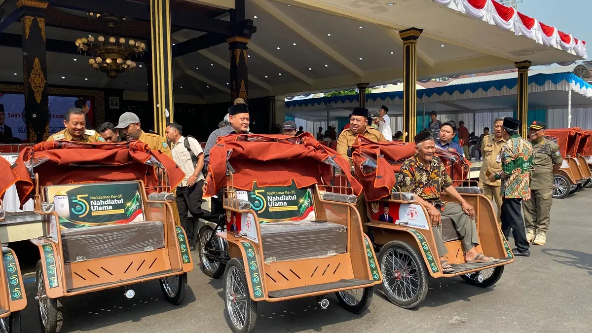 DICOBA: Bupati Jombang Warsubi bersama Ketua Panlok Muktamar ke-35 NU KH Abdurrozaq Sholeh (Gus Rozaq) menjajal becak listrik bantuan Prabowo, Senin (24/8). (Anggi Fridianto/Radar Jombang)