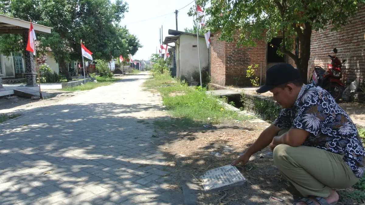 TUNJANG MOBILITAS WARGA: Kaur Perencanaan Desa Ngrandulor Lukman Ali menunjukkan lokasi pembangunan jalan paving di Dusun Ngumpak, Desa Ngrandulor, Peterongan, Jombang. (Dwi Aris/Radar Jombang)