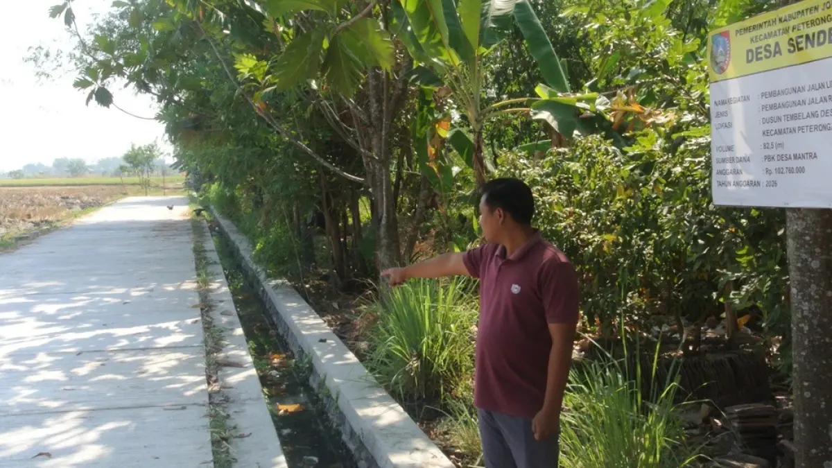 JALAN BARU: Kaur Perencanaan Desa Senden Roisul Arif menunjukkan lokasi jalan rigid beton alokasi program Desa Mantra di Dusun Tembelang, Desa Senden, Peterongan, Jombang. (Dwi Aris/Radar Jombang)