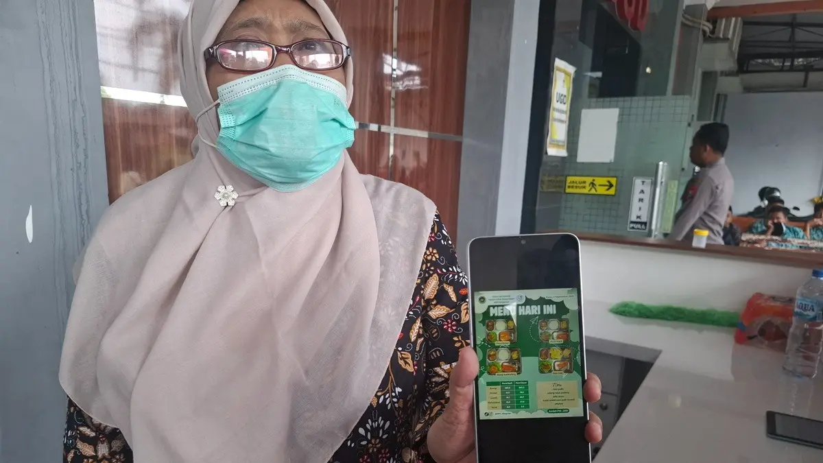 Sanitarian Puskesmas Kabuh, Jombang, Eli Setyowati menunjukkan menu makanan MBG yang disantap siswa. (Achmad RW/Radar Jombang)