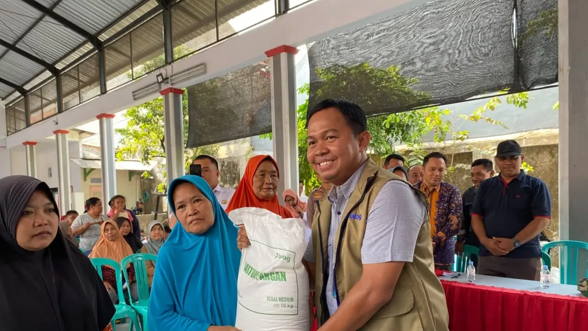 DISALURKAN: Pimpinan Cabang Perum Bulog Mojokerto Mohammad Husin meneyrahkan bantuan beras kepada penerima manfaar di Balai Desa Bareng, Jombang, Rabu (9/9). (Anggi Fridianto/Radar Jombang)