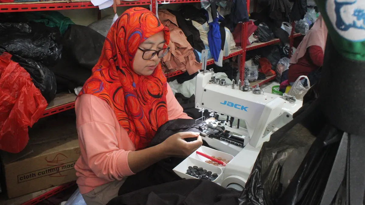 RAPI: Koordinator penjahit di Desa Plosogeneng Kecamatan Jombang melakukan packing seragam yang sudah selesai dijahit, (3/9). (Wenny Rosalina/Radar Jombang)