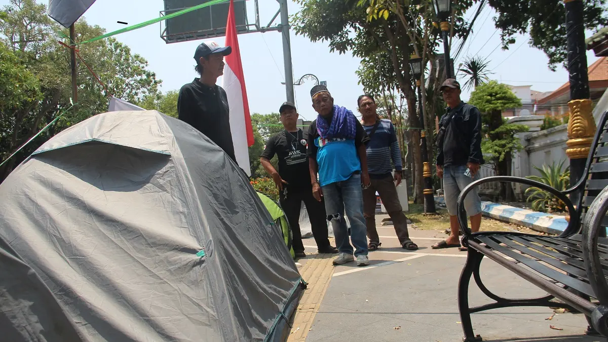 BENTUK PROTES: Sejumlah massa masih menggelar kemah di depan Kantor Pemkab Jombang, Rabu (16/9). (Anggi Fridianto/Radar Jombang)