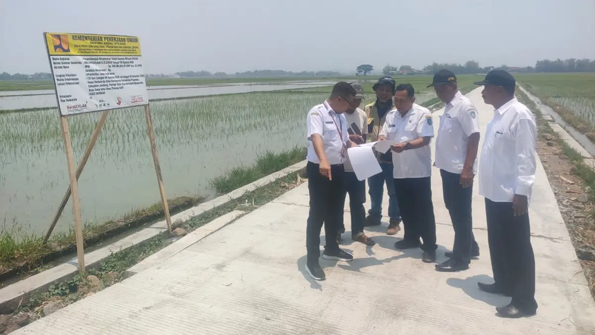 BANGUN DESA: (dari kanan) Kepala Desa Karangmojo Suwita, Kepala Desa Jatimlerek Jadi, Kasi PMD Kecamatan Plandaan Daniel Danang Darmawan, FM Kecamatan Plandaaan Shobahul Munir, Rismono Ketua Pokmas KAD dan perwakilan Dinas Perkim Kabupaten Jombang berkoordinasi saat mengecek bangunan jalan rigid beton di Dusun Tambakrejo, Desa Karangmojo, Rabu (30/9) siang. (Dwi Aris/Radar Jombang)
