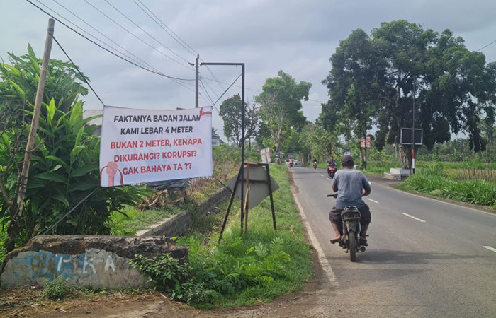 Warga Dusun Curah Lor kembali pasang spanduk sebagai bentuk aspirasi. Mereka ingin jalan penghubung antardusun itu diperlebar dan ditinggikan. (NAILA NIHAYAH/RADAR JOGJA)