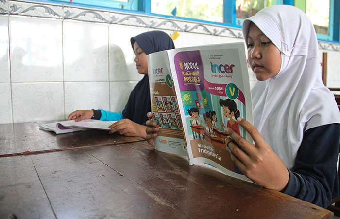 KONSENTRASI: Siswi SD Negeri 1 Bantul membaca buku kurikulum merdeka mata pelajaran Bahasa Indonesia. (Gregorius Bramantyo/Radar Jogja)
