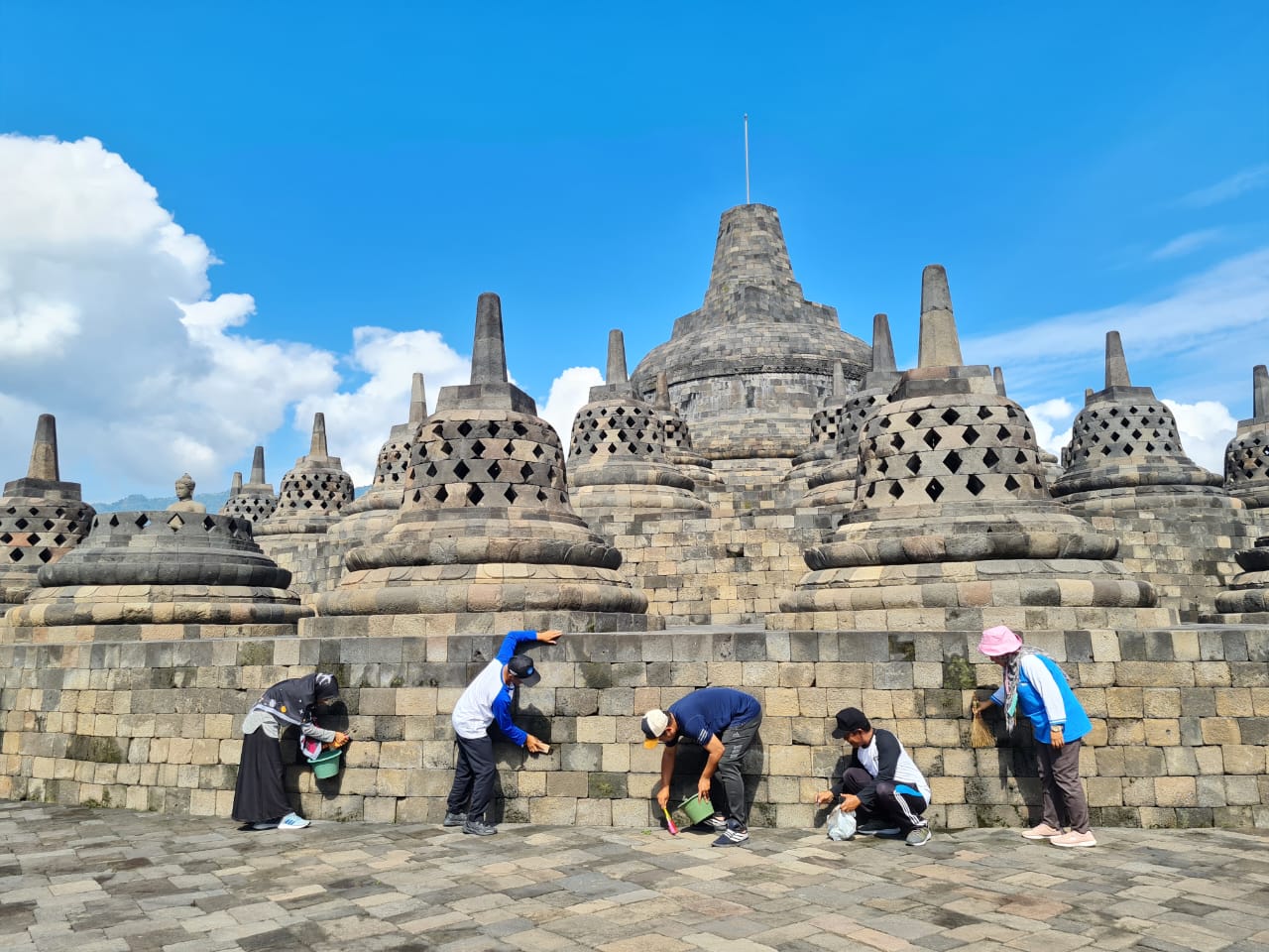 RERESIK: Para pekerja membersihkan bebatuan candi dari lumut maupun mikroorganisme lain. Ini berlaku baik secara kering maupun basah. (Naila Nihayah/Radar Jogja)