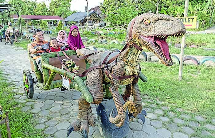 SERU: Pengunjung saat menaiki dino dokar yang berada di Taman Dinosaurus Potorono atau Potorono Edu Park di Banguntapan, Bantul kemarin (9/12).