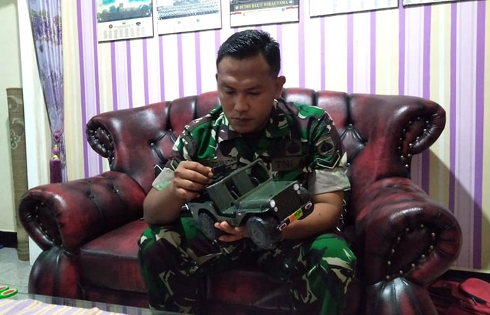 KARYA SENI: Serda TNI Eka&nbsp;Mardiyanto&nbsp;Anggota Kodim 0709/Kebumen memegang miniatur kendaraan tempur jenis Jeep&nbsp;Willys yang dibuat dari barang rongsok.