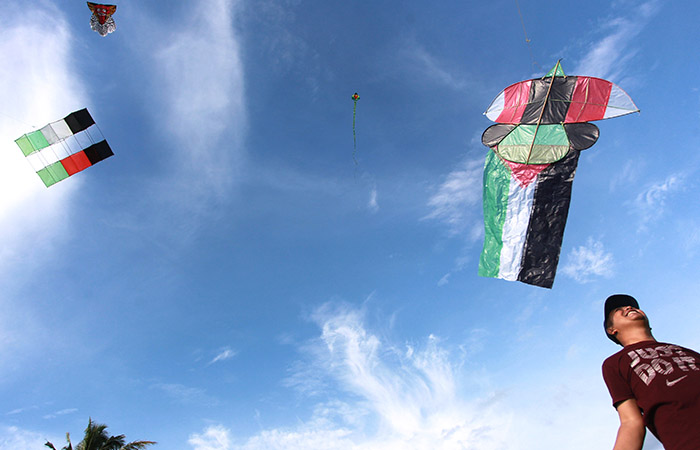 SOLIDARITAS: Warga menerbangkan layang-layang di area persawahan Padukuhan Ngaran, Margokaton, Seyegan kemarin (14/1). Kegiatan bertajuk "Fly A Kite for Gaza" itu untuk memperingati Hari Layang-Layang