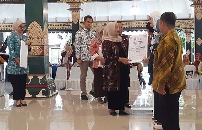 SIMBOLIS: Bupati Kustini Sri Purnomo saat memberikan sertifikat halal gratis kepada pelaku usaha di Pendopo Parasamya Pemkab Sleman kemarin (24/1).